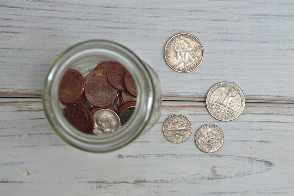 Savings jar with coins next to phone