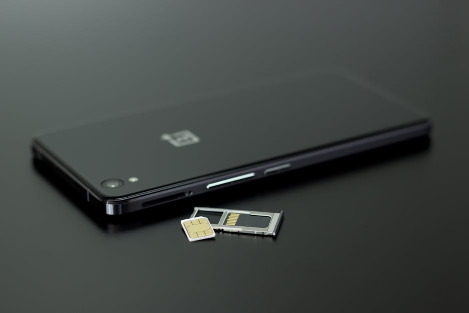 Hand holding smartphone with SIM card tray open
