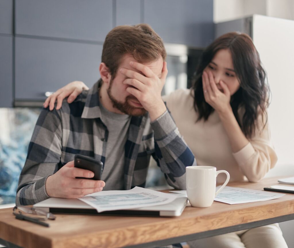 Person reviewing household bills and letters at a kitchen table, representing council tax arrears