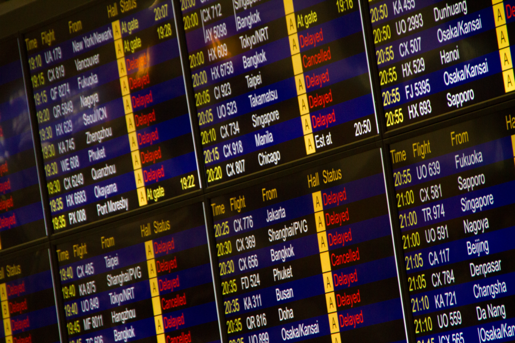Airport departure board showing delayed flights in the UK