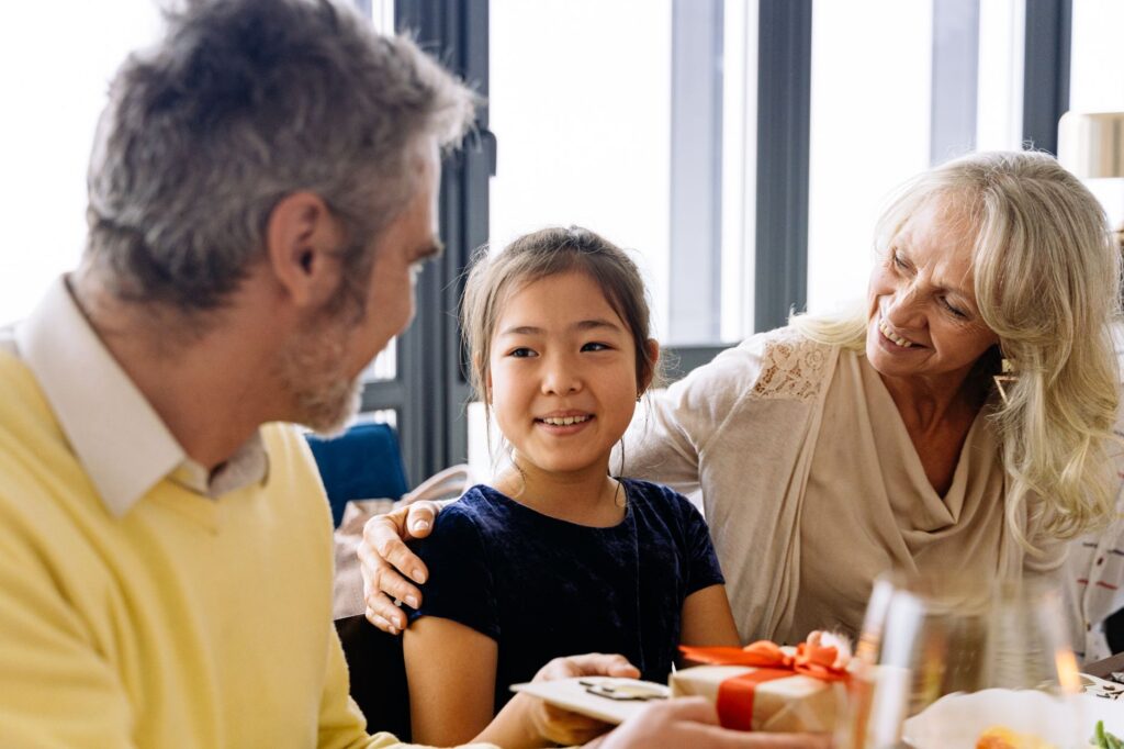 Grandparents handing a gift to a grandchild, illustrating UK family gifting and inheritance tax allowances