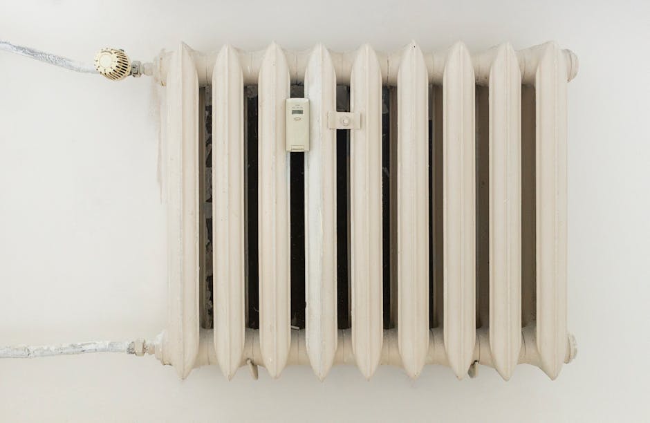 Hand adjusting a home heating thermostat in winter