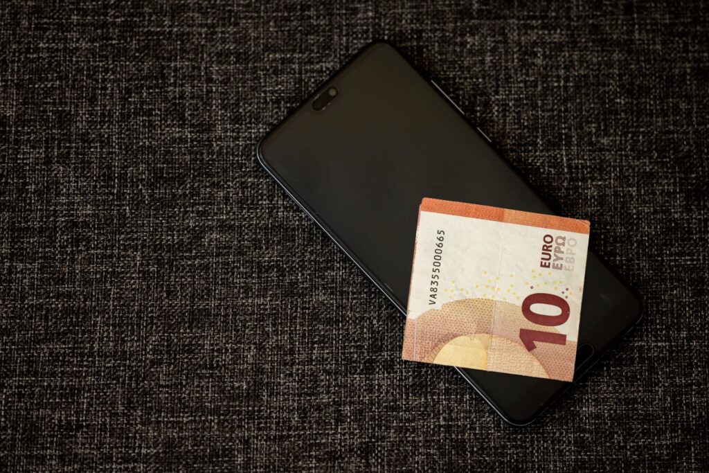 Person using a smartphone cashback rewards app to save money on their phone bill