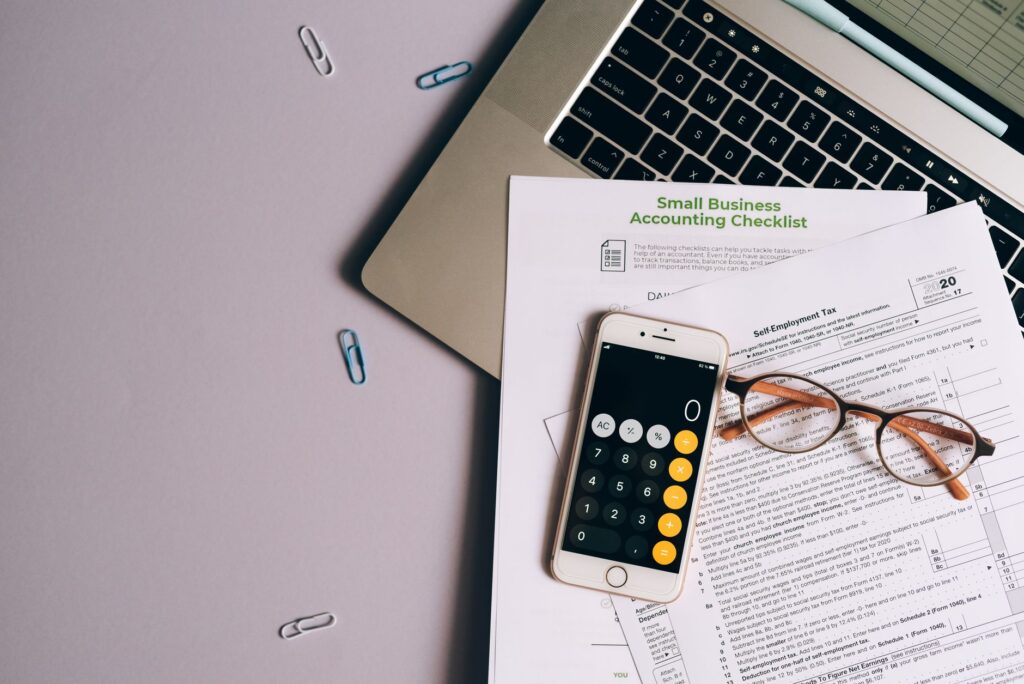 Calculator, pen and financial paperwork on a desk representing UK Capital Gains Tax planning for 2026