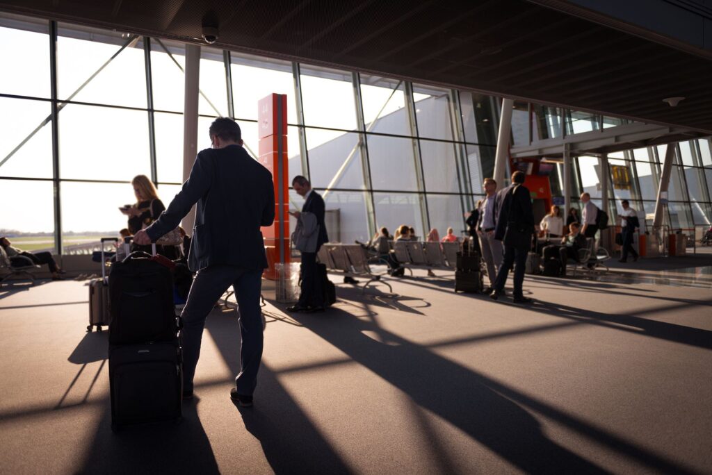 Traveller with a wheeled cabin suitcase at an airport boarding gate