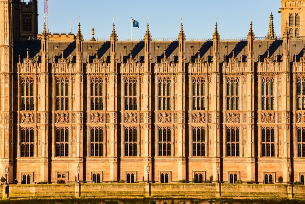 The Palace of Westminster in London, home of the House of Commons, lit by late sunlight.